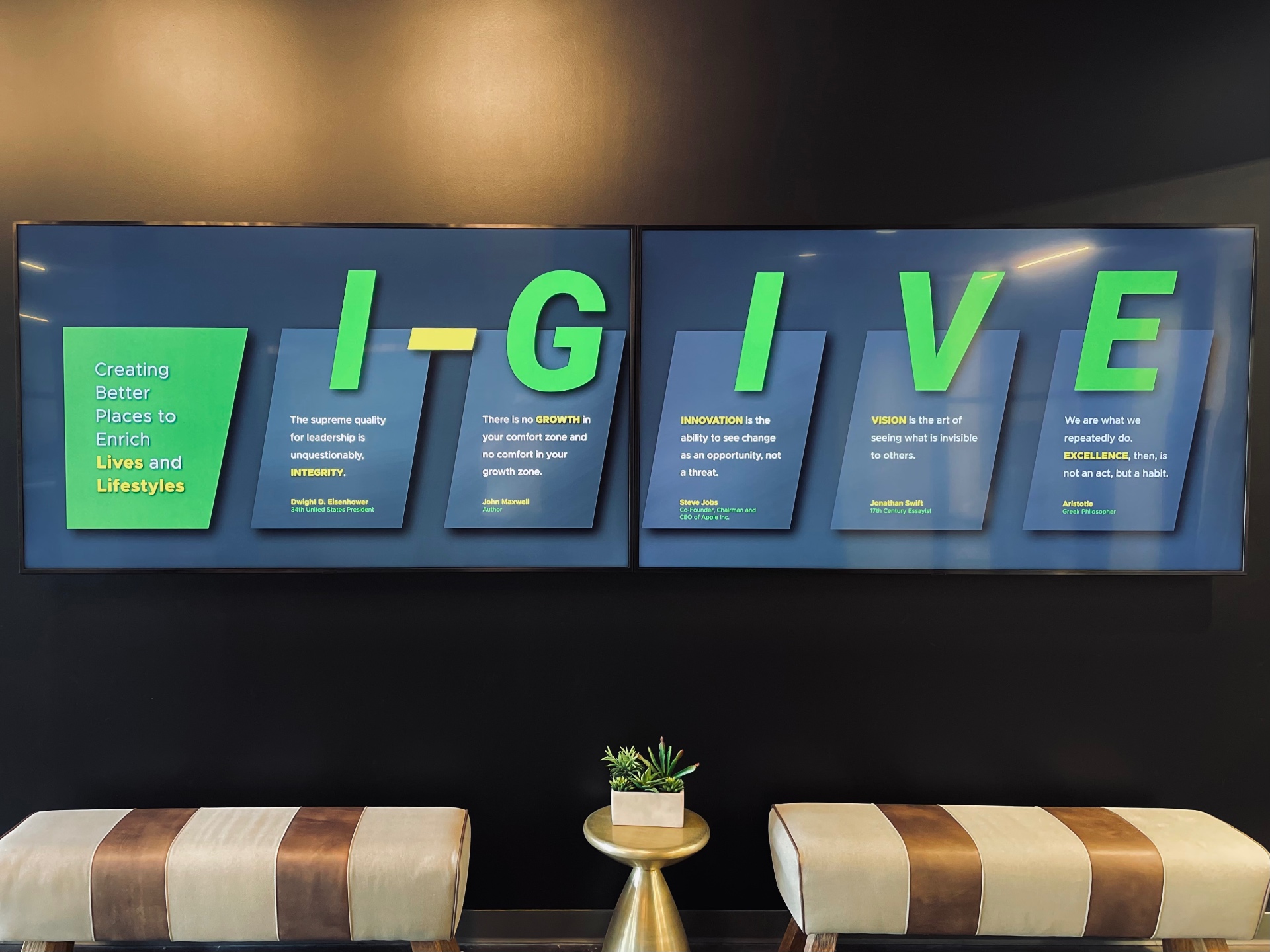 Lobby digital signage — dual displays running branded core-values content above lounge seating