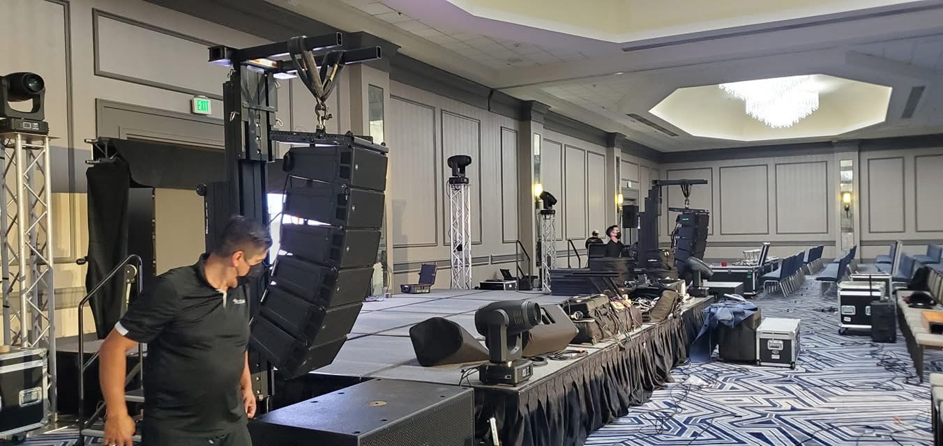 Flown line array and moving-head lights in a hotel ballroom load-in